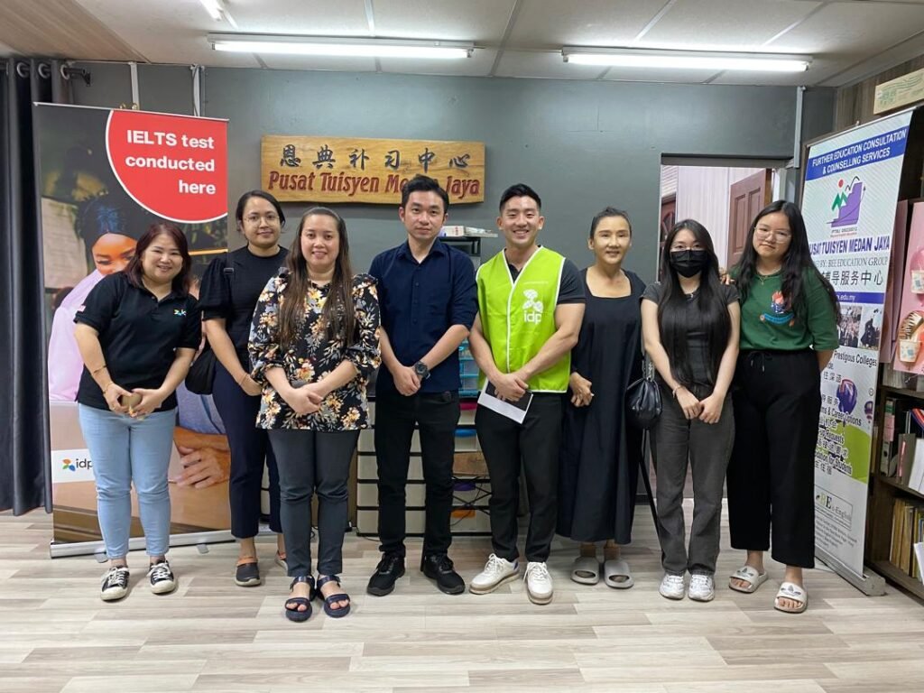 Group photo of IELTS invigilators and test takers at exam centre