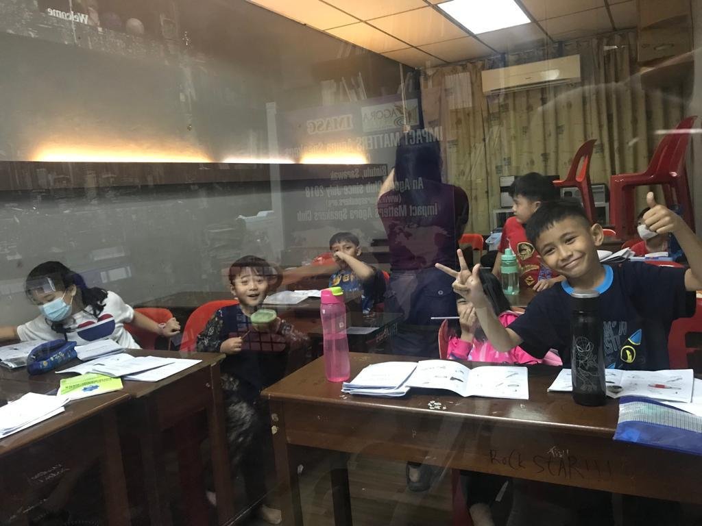 Group of primary school students listening to teacher