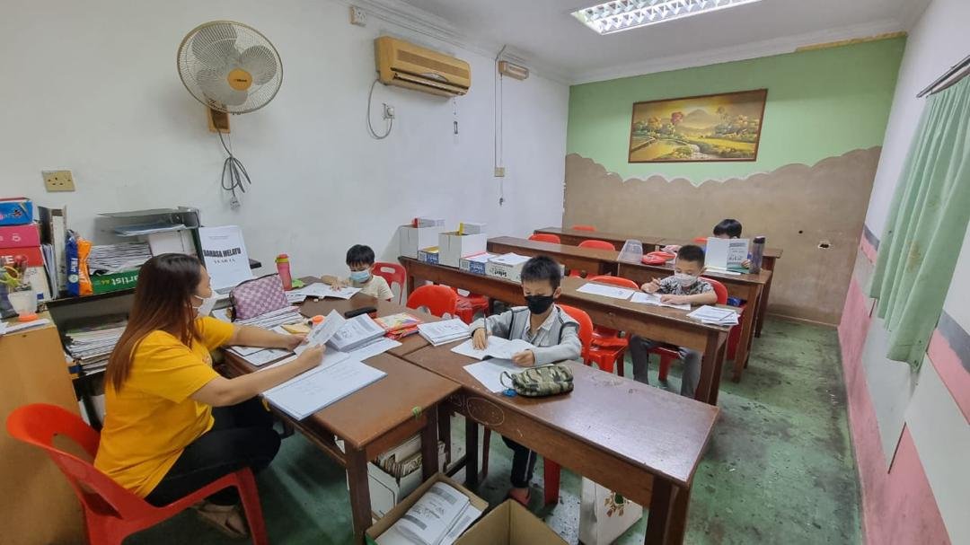 English teacher guiding junior students through reading activity